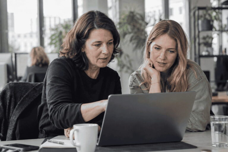 Symbolbild: Zwei Kolleginnen arbeiten gemeinsam am Laptop