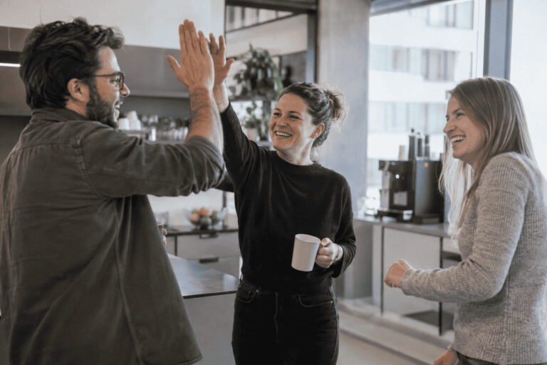 Symbolbild: Team feiert eine erfolgreiche Vermittlung mit High Five