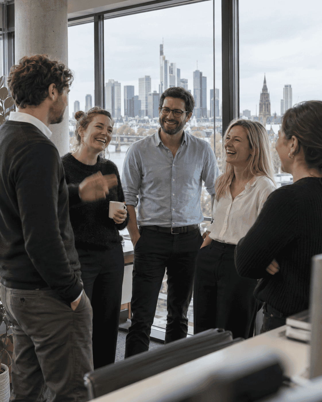 Symbolbild: Team im Gespräch mit Blick auf die Frankfurter Skyline